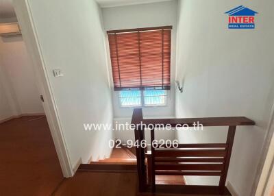 Interior staircase with wooden railing and window