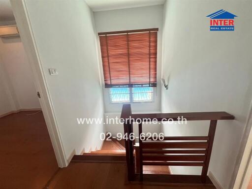 Interior staircase with wooden railing and window