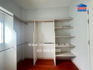 Spacious walk-in closet with built-in shelving and hanging rods