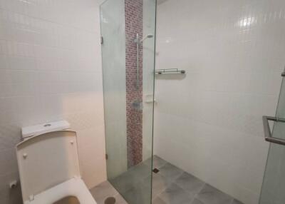 Modern bathroom with glass shower door and tiled wall accent