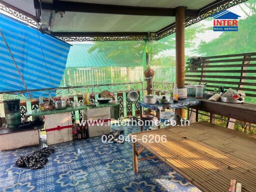 Covered outdoor patio area with cooking utensils and bamboo seating