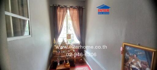 Small room with decorated shrine and window with curtains