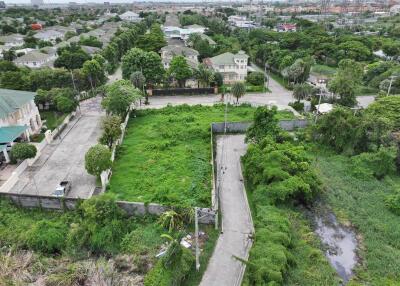 Aerial view of a neighborhood with residential houses and green vacant land