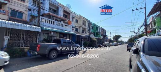 Street view of residential buildings with parked cars