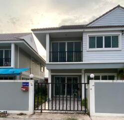 Front view of a two-story house with a fenced yard