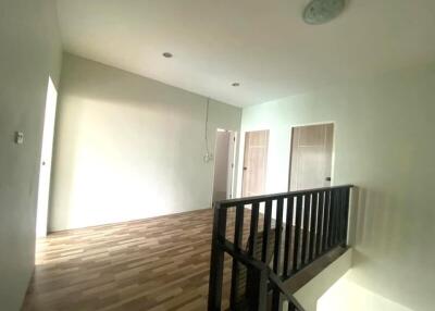 Upstairs hallway with wooden flooring and railings