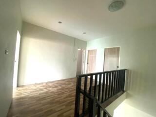 Upstairs hallway with wooden flooring and railings