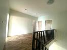 Upstairs hallway with wooden flooring and railings