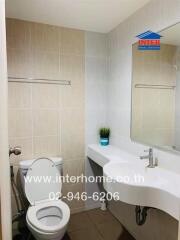 Modern bathroom with white ceramic fixtures and a large mirror