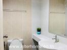 Modern bathroom with white ceramic fixtures and a large mirror