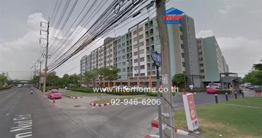 Exterior view of a multi-story residential building with parking area