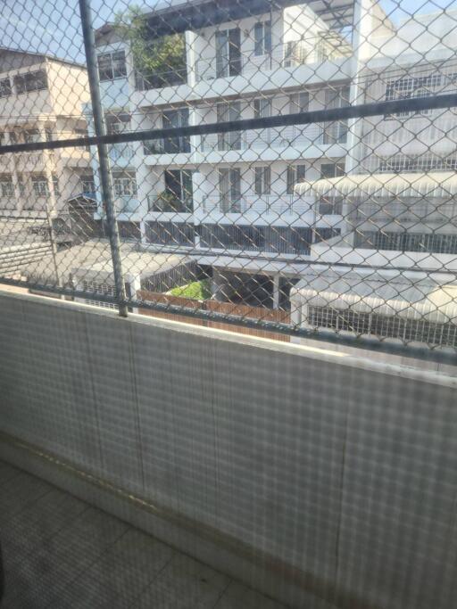 View of buildings from a balcony with a safety net