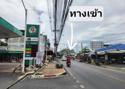 Street view with gas station, buildings, and a motorcycle