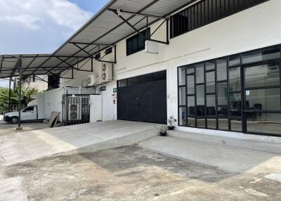 Exterior view of a commercial building with large windows and loading area