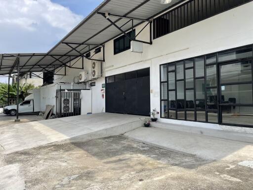 Exterior view of a commercial building with large windows and loading area