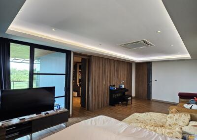 Spacious and modern bedroom with a large bed and a TV