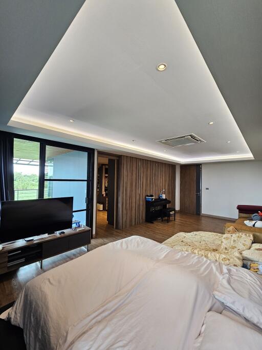 Spacious and modern bedroom with a large bed and a TV