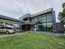 Modern house front view with large glass windows and carport