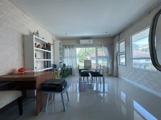 Spacious and well-lit living room with large windows and modern furniture