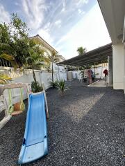 Outdoor play area with slide and gravel flooring