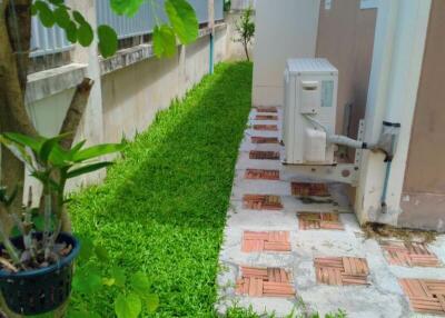 Side yard with green grass and air conditioning unit