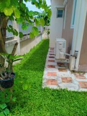 Side yard with green grass and air conditioning unit