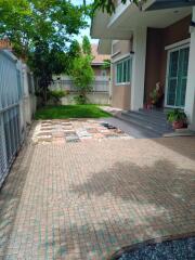 Front view of a house with tiled driveway and garden area