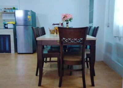 Dining area with a wooden table and chairs, adjacent to the kitchen