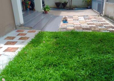 Front yard with grass, step stones, and driveway