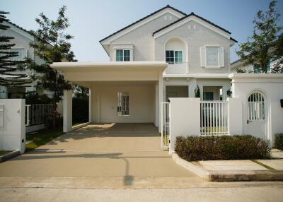 White two-story house with a carport