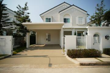 White two-story house with a carport