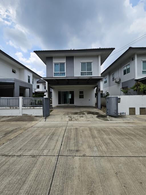 Front view of a modern two-story house with attached carport