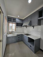 Modern kitchen with grey cabinetry and white backsplash