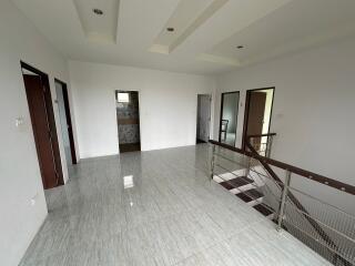 Spacious and modern upstairs hallway with tiled flooring and access to multiple rooms