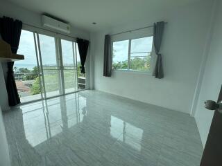 Spacious bedroom with large windows and balcony