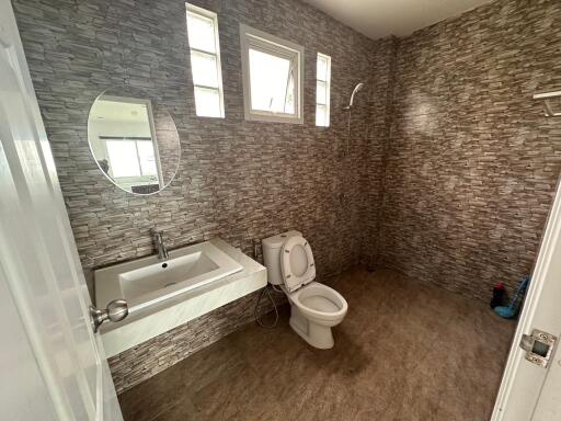 Modern bathroom with tiled walls and a large mirror.