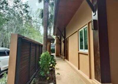 Exterior view of a modern building with wooden beams and lush green plants