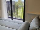 Cozy bedroom with a view of a balcony and greenery