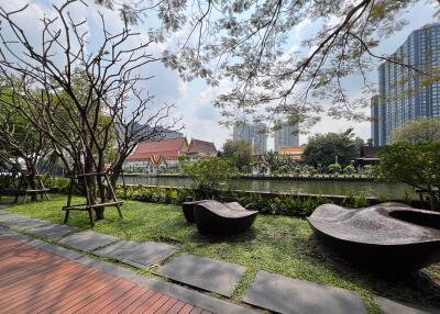 Outdoor seating with view of a pond and buildings in the background
