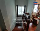 Staircase leading down with a view of a window and part of the living room