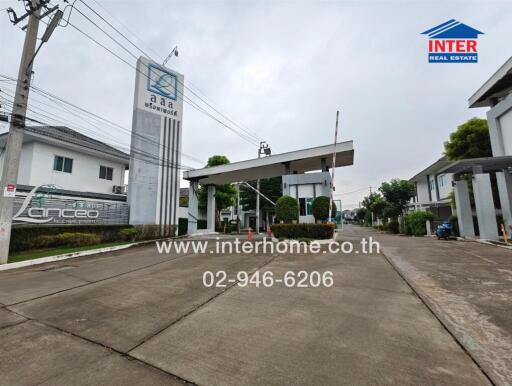 Entrance of a residential complex with security gate and signage