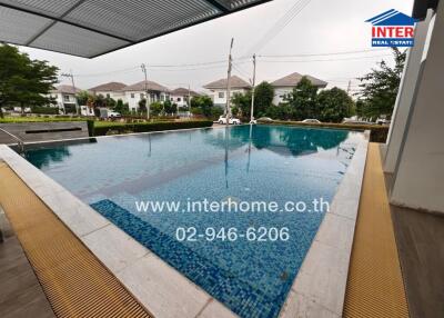 Outdoor swimming pool with tiled flooring and seating area