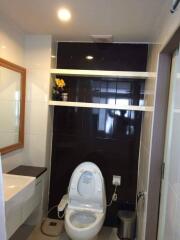 Modern bathroom with dark accent wall and toilet