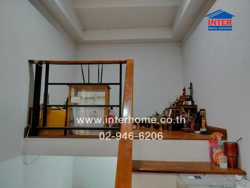 Interior stairway with railing and small personal items on shelves