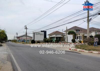 Street view showing houses and a real estate sign