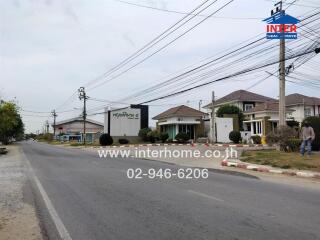 Street view showing houses and a real estate sign