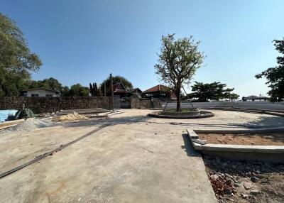 Construction site with surrounding houses and trees