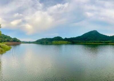 Scenic view of a lake surrounded by greenery and mountain in the background