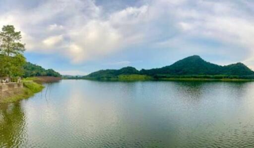 Scenic view of a lake surrounded by greenery and mountain in the background