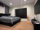 Modern bedroom with large bed, wooden floor, and wall-mounted TV